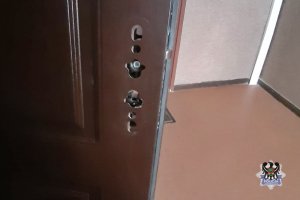 Na zdjęciu uszkodzone drzwi wejściowe do mieszkania.