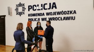Na zdjęciu przekazanie roweru drugiemu z dzieci.