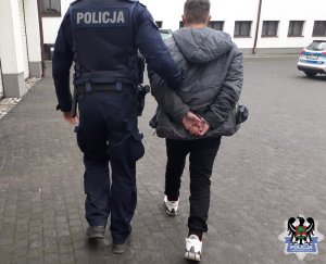 Policjant prowadzi zatrzymanego