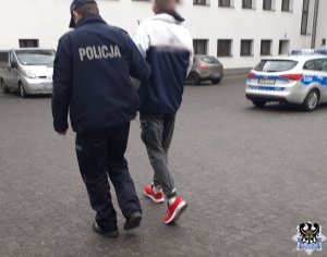 policjant prowadzi zatrzymanego