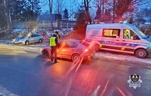 Na zdjęciu radiowóz oraz policjant przeprowadzający badanie stanu trzeźwości - kolejne ujęcie.