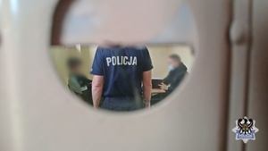 Na zdjęciu policjanci wykonują czynności procesowe z zatrzymanym mężczyzną.