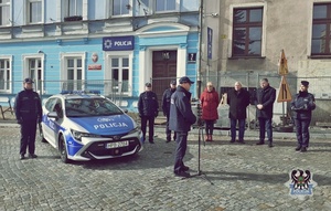 Na zdjęciu nowy radiowóz oraz uczestnicy przekazania pojazdu służbowego.