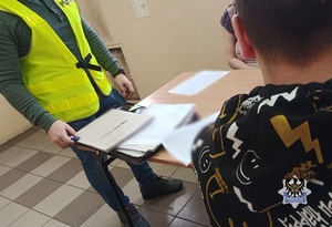 Na zdjęciu policjanci wykonują czynności z zatrzymaną kobietą.