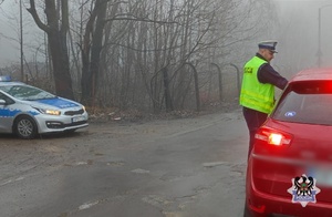 Na zdjęciu policjant bada stan trzeźwości na ul. Piotrowskiego - inne ujęcie.