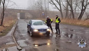 Na zdjęciu policjant bada stan trzeźwości na ul. Prostopadłej - inne ujęcie.