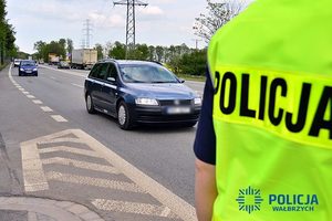 Na zdjęciu policjant oraz samochody na drodze.