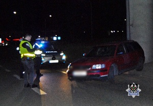 Na zdjęciu policjanci na miejscu zdarzenia przy kontrolowanym samochodzie - trzecie ujęcie.
