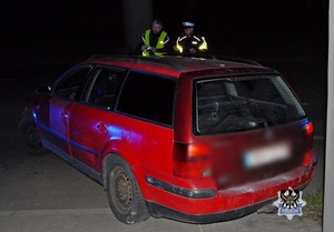 Na zdjęciu policjanci na miejscu zdarzenia przy kontrolowanym samochodzie - drugie ujęcie.