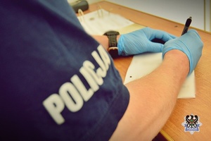Na zdjęciu policjant sporządza dokumentację.