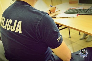 Na zdjęciu policjanci wykonują czynności procesowe z zatrzymanym mężczyzną.