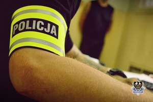 Na zdjęciu policjant prowadzi czynności procesowe z zatrzymanym mężczyzną.