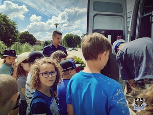 Na zdjęciu policjanci demonstrują sprzęt wykorzystywany w służbie, w tym radiowóz.
