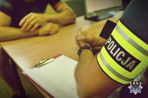 Na zdjęciu policjanci wykonują czynności procesowe z kolejnym zatrzymanym mężczyzną.