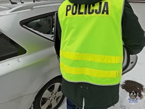 Na zdjęciu policjant przy radiowozie.