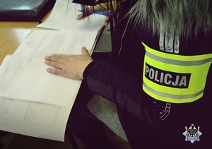 Na zdjęciu policjantka prowadzi czynności procesowe z zatrzymanym mężczyzną