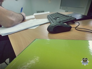 Na zdjęciu policjant sporządza dokumentację służbową.