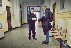 Na zdjęciu policjant rozmawia ze studentami.