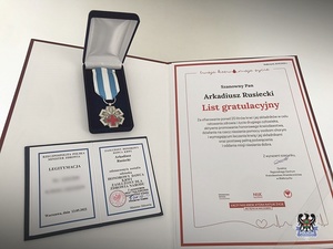 Na zdjeciu list gratulacyjny, legitymacja oraz pamiątkowy medal.