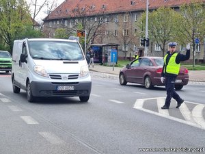 Na zdjęciu jeden z policjantów ręcznie kierujący ruchem na drodze.