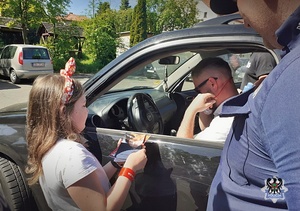 Na zdjęciu policjanci, dzieci oraz kierujący podczas akcji Jabłko i cytryna.