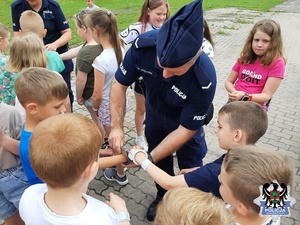 policjantka prezentująca dzieciom  kajdanki