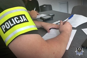 Na zdjęciu policjanci sporządzają dokumentację służbową.