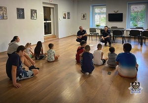 Na zdjęciu policjanci prowadzą pogadankę z dziećmi.