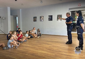 Na zdjęciu policjanci prowadzą pogadankę z dziećmi.