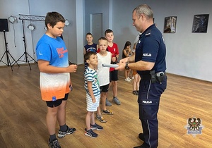 Na zdjęciu policjanci prowadzą pogadankę z dziećmi.