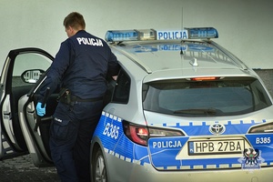 Na zdjęciu policjant wsiada do radiowozu.