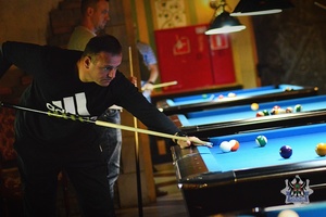 Na zdjęciu zawodnik podczas gry przy stole bilardowym.