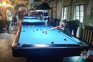 Na zdjęciu zawodnik podczas gry przy stole bilardowym.