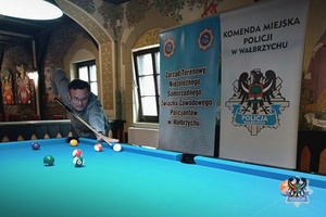 Na zdjęciu zawodnik podczas gry przy stole bilardowym.