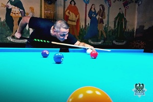 Na zdjęciu zawodnik podczas gry przy stole bilardowym.