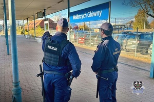 Na zdjęciu policjant oraz funkcjonariusz Straży Ochrony Kolei na dworcu.