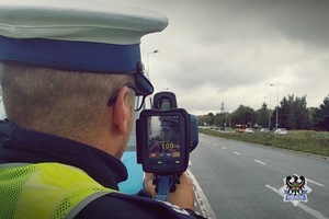 Na zdjęciu policjant z ręcznym miernikiem prędkości.