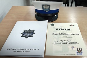 Na zdjęciu czapka służbowa oraz dyplom dla. mł. asp. Grzegorza Koszkula.