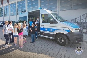 Na zdjęciu policjant oraz dzieci uczestniczące w festynie.