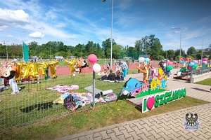 Na zdjęciu policjant oraz dzieci uczestniczące w festynie.