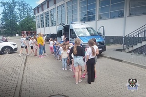 Na zdjęciu policjant oraz dzieci uczestniczące w festynie.