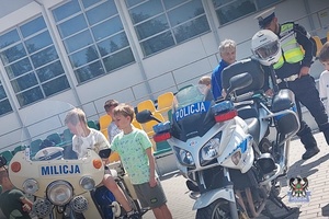 Na zdjęciu policjant oraz dzieci uczestniczące w festynie.