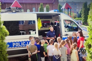 Na zdjęciu policjant oraz dzieci uczestniczące w festynie.