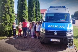 Na zdjęciu policjant oraz dzieci uczestniczące w festynie.