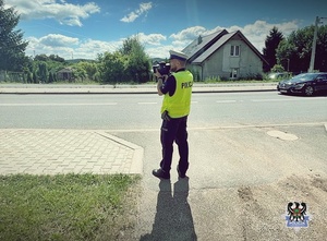 Na zdjęciu policjant z ręcznym miernikiem prędkości.