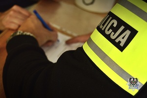 Na zdjęciu policjant sporządza dokumentacje służbową.