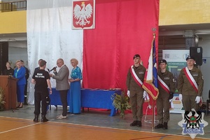 Zdjęcie przedstawiające uczniów IV liceum ogólnokształcącego otrzymujących świadectwa oraz dyplomu od policjantów