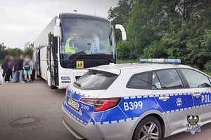 Na zdjęciu autokar oraz radiowóz policyjny.