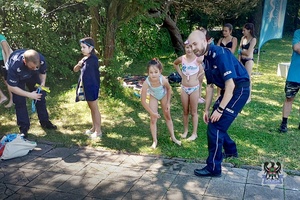 Na zdjęciu policjanci podczas spotkania z dziećmi na basenie.