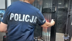 Na zdjeciu policjantka umieszcza zatrzymaną w radiowozie.